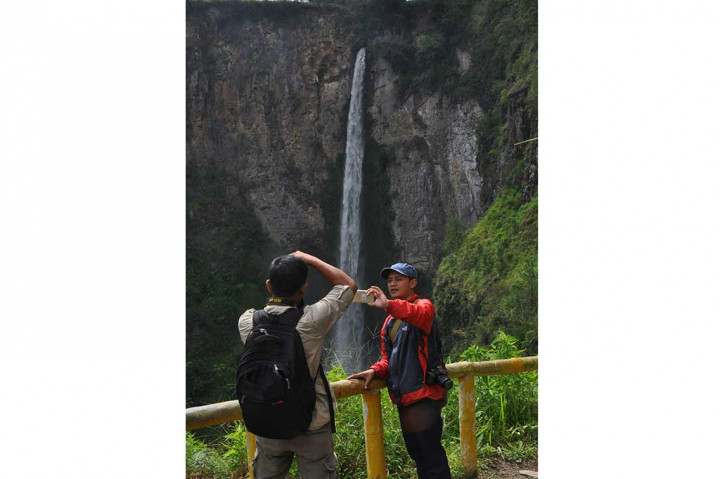 Pengunjung menikmati keindahan air terjun Sipiso-Piso.