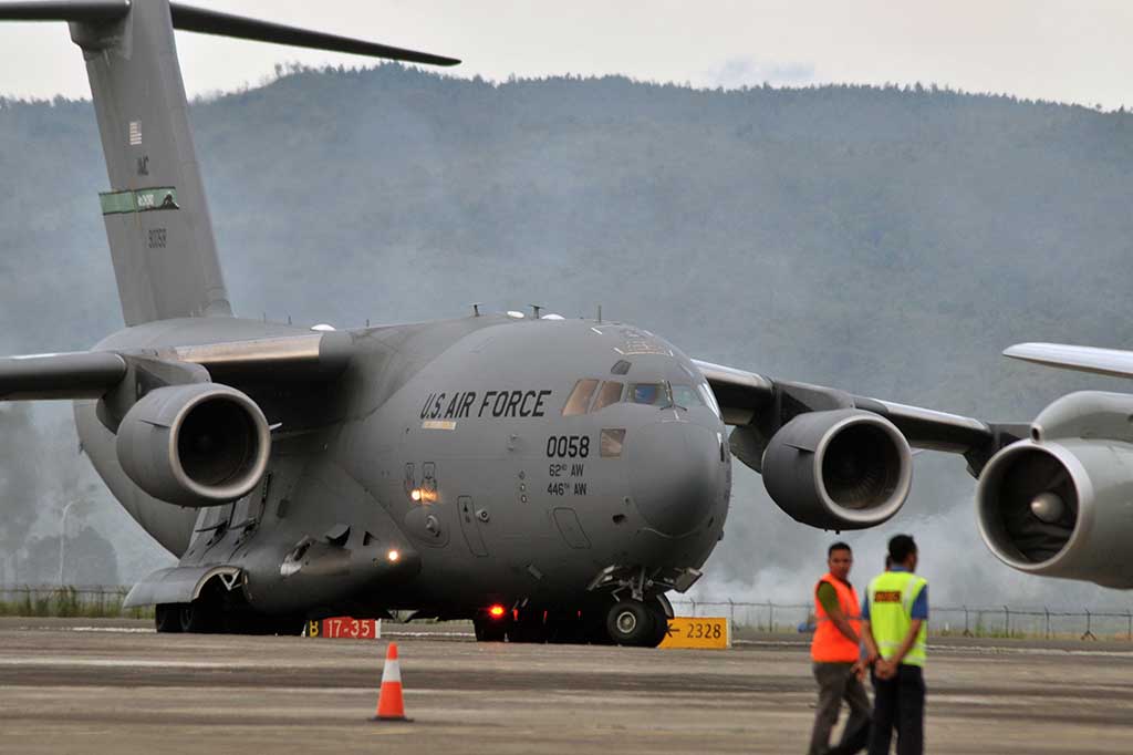 Petugas bandara mengawasi pesawat militer AS jenis Boeing C-17 yang mendarat di Bandara Internasional Sultan Iskandar Muda, Blangbintang, Aceh Besar, Aceh, Selasa (4/4/2017).