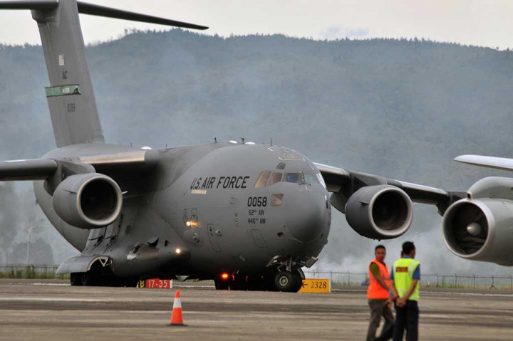 Petugas bandara mengawasi pesawat militer AS jenis Boeing C-17 yang mendarat di Bandara Internasional Sultan Iskandar Muda, Blangbintang, Aceh Besar, Aceh, Selasa (4/4/2017).