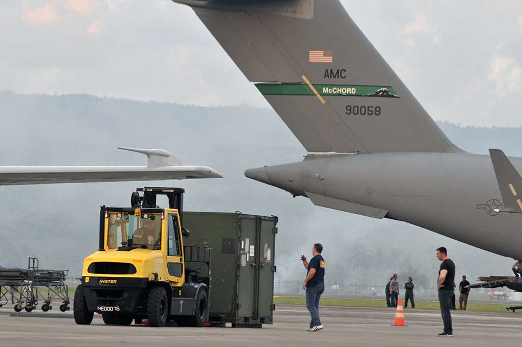 Personel militer AS menurunkan kontainer berisi mesin pesawat dan peralatan lainnya dari pesawat US Air Forse. Kedatangan pesawat AS bersama sejumlah teknisi itu untuk memperbaiki pesawat militer mereka yang sudah 11 hari berada di Aceh karena mengalami kerusakan mesin.
