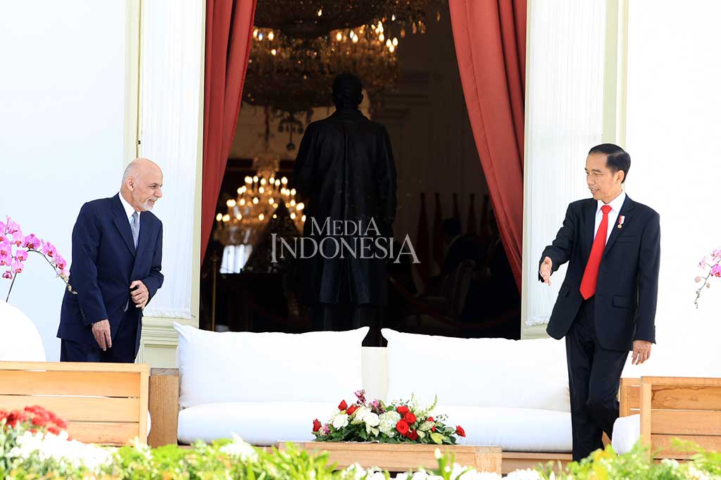 Presiden Jokowi mempersilahkan duduk Presiden Afghanistan sebelum melakukan perbincangan di beranda belakang Istana Merdeka.