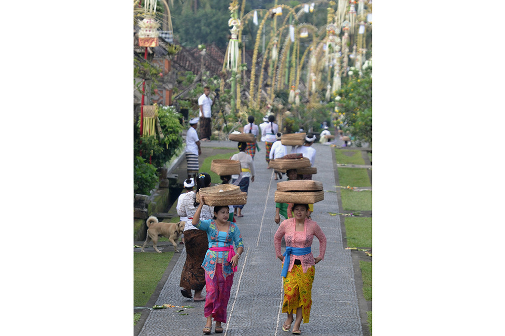 Sejumlah wanita menjunjung sesaji saat Hari Raya Galungan di Desa Adat Penglipuran, Bangli, Bali.