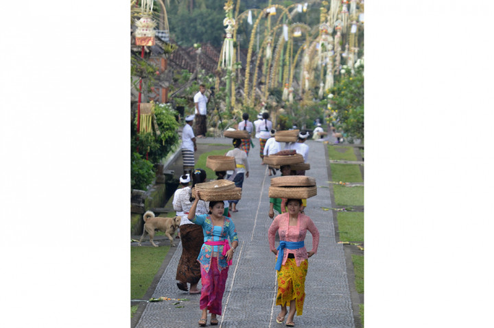 Sejumlah wanita menjunjung sesaji saat Hari Raya Galungan di Desa Adat Penglipuran, Bangli, Bali.