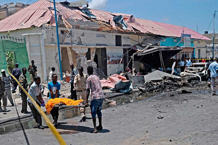 Warga mengevakuasi korban tewas akibat bom mobil yang meledak di depan sebuah restoran di Mogadishu, Somalia, Rabu (5/4/2017) waktu setempat.