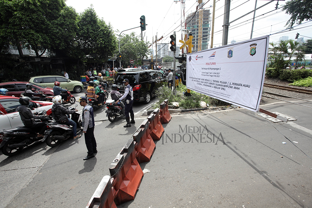 Petugas Dishub DKI Jakarta melakukan uji coba penutupan perlintasan sebidang di Jalan Pejompongan 1, Jakarta Pusat, Jumat (7/4/2017).