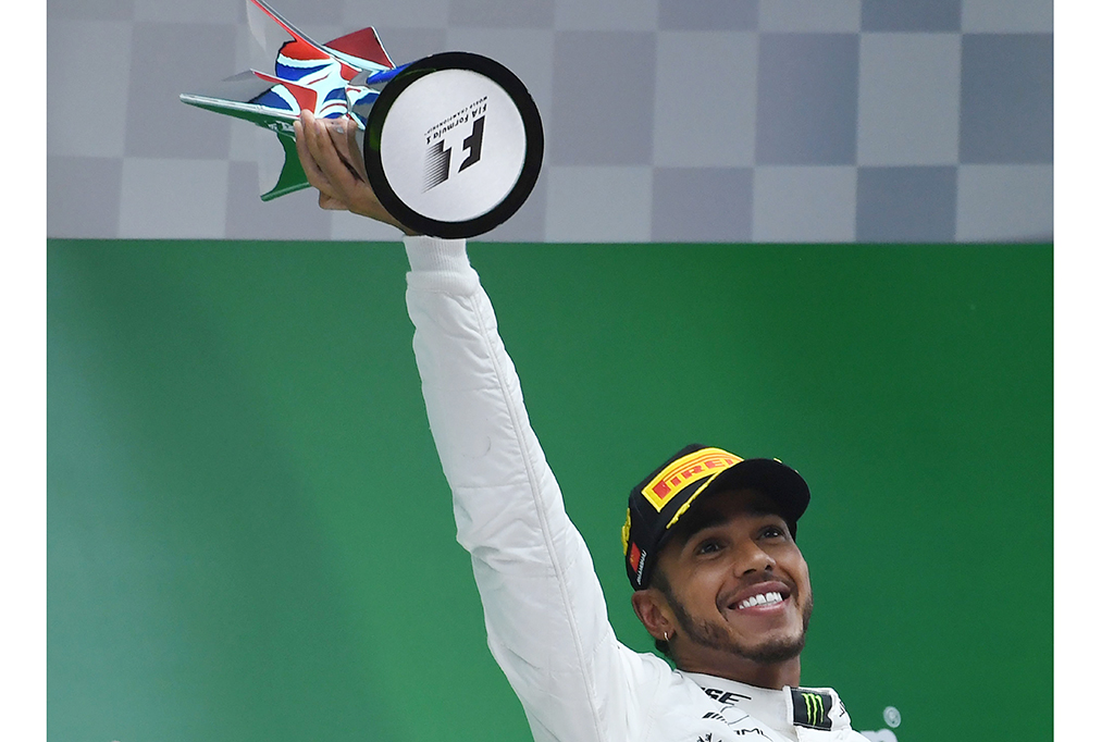 Hamilton mengangkat trofi juara GP Tiongkok. Kemenangan ini membuat persaingan Hamilton dan Vettel semakin memanas karena sama-sama mengantongi 43 poin.