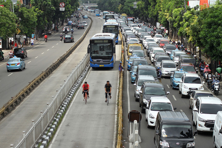 Dua pesepeda melaju di jalur busway untuk menghindari kemacetan di Jalan Mampang, Jakarta Selatan.