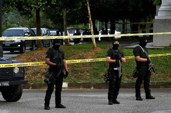Aparat polisi bersenjata, berpakaian seragam hitam dengan menggunakan penutup wajah sebatas mata bersiaga di dalam komplek mahkamah.