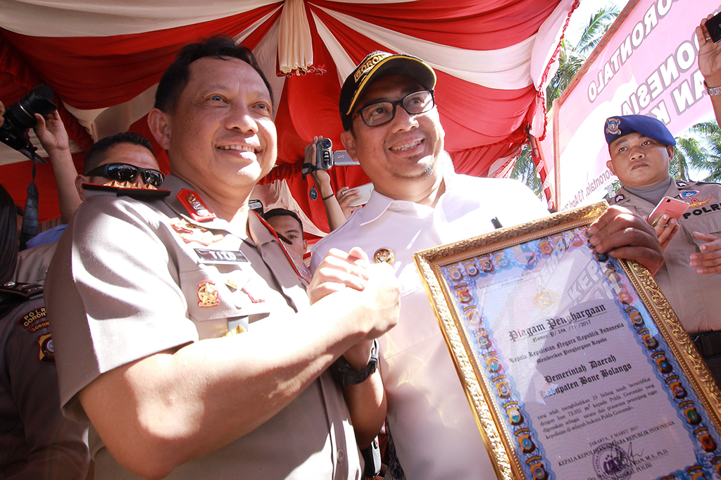 Kapolri Jenderal Tito Karnavian (kiri) memberikan penghargaan kepada Bupati Bone Bolango Hamim Pou di Batudaa, Kabupaten Gorontalo