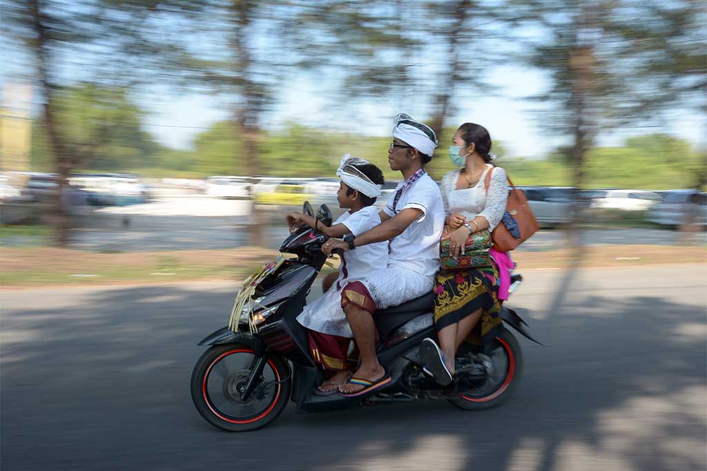 Umat Hindu naik kendaraan bermotor menuju tempat persembahyangan Hari Raya Kuningan di Pura Sakenan, Denpasar, Bali, Sabtu (15/4/2017).