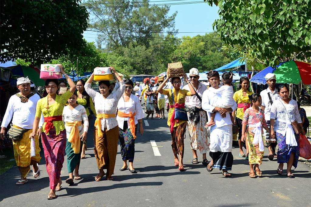 Umat Hindu membawa sesajen saat akan bersembahyang di sebuah Pura di Denpasar. AFP/Sony Tumbelaka