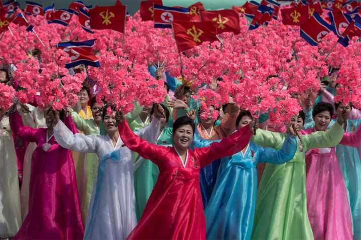 Ratusan wanita dengan pakaian tradisional Korea saat berparade melintasi pemimpin Korut Kim Jong-Un.
