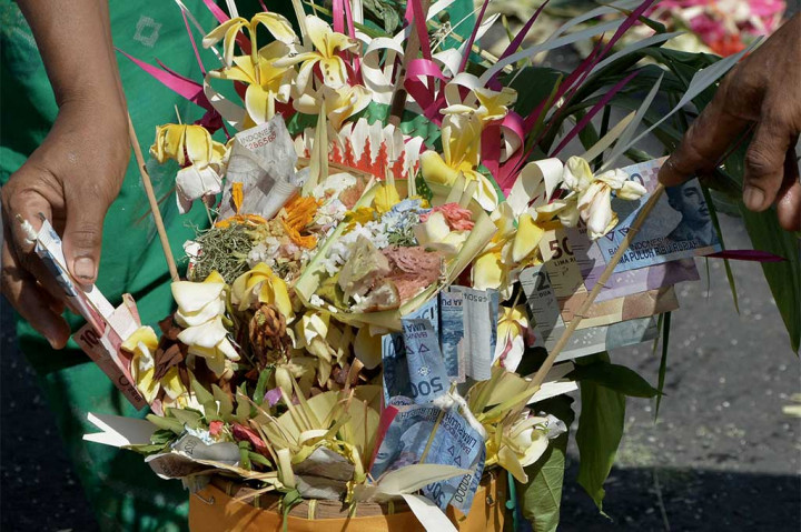 Warga menyiapkan uang yang akan dibagikan saat Tradisi Mesuryak di Desa Bongan, Tabanan, Bali, Sabtu (15/4/2017).
