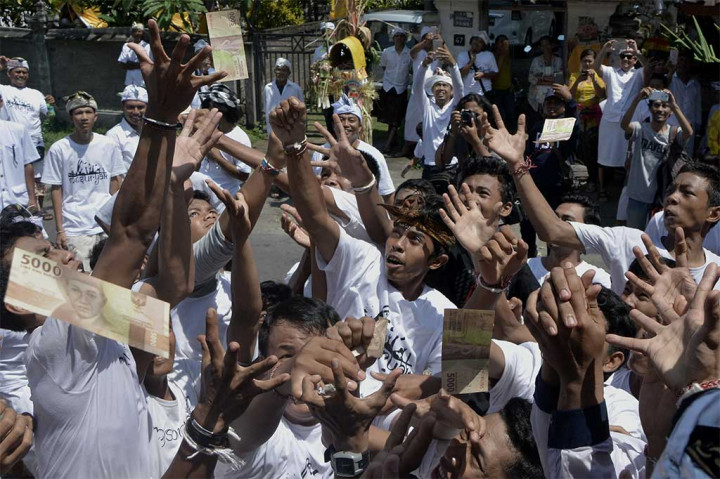 Warga saling berebut uang yang dilempar saat Tradisi Mesuryak.