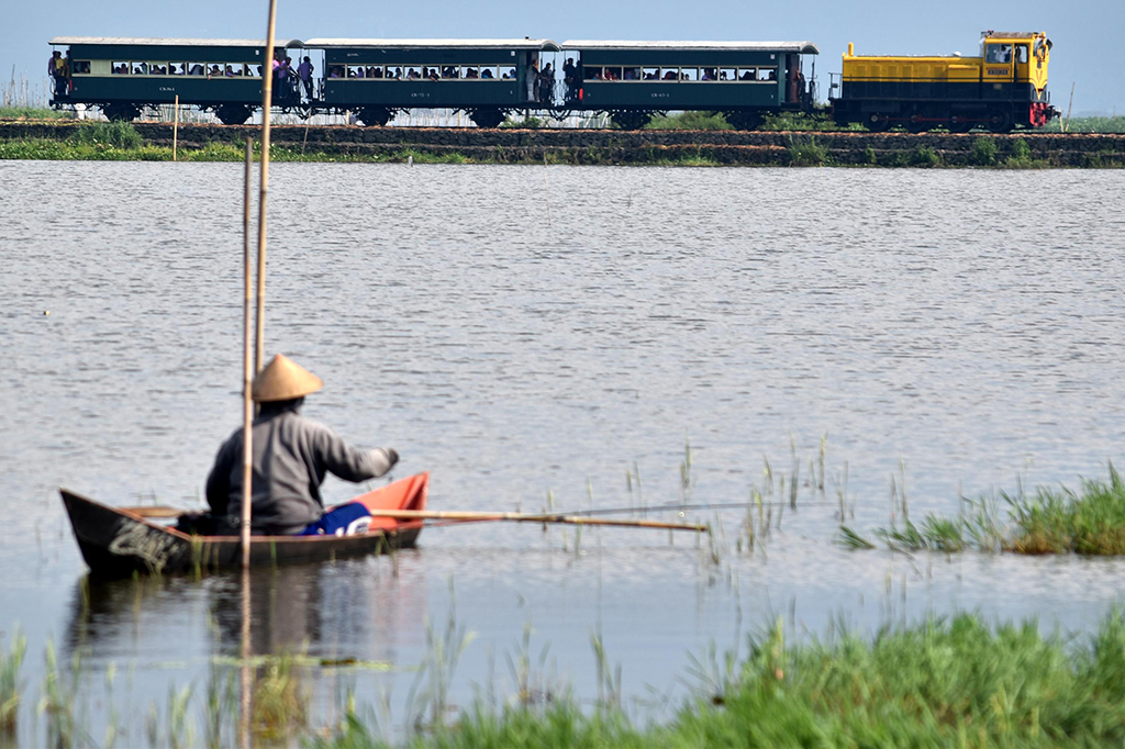 Rangkaian kereta api kuno membawa sejumlah wisatawan melintasi kawasan Rawa Pening di Bawen, Kabupaten Semarang, Jawa Tengah, Minggu (16/4/2017).