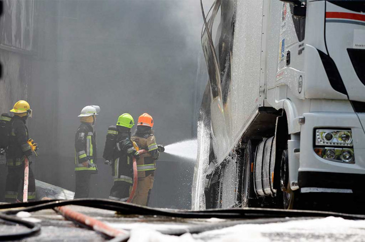 Petugas pemadam kebakaran berusaha memadamkan api yang membakar sebuah truk setelah sebuah pesawat ringan menabrak sebuah gudang supermarkt di Ban, dekat Sintra, sekitar 20 kilometer (12 mil) dari Kota Lisabon, Senin (17/4/2017) waktu setempat.