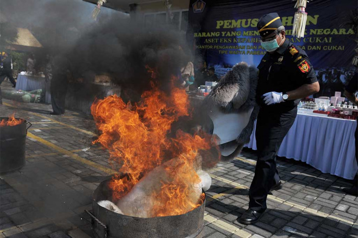 Petugas membakar barang ilegal saat pemusnahan barang yang telah menjadi milik negara.