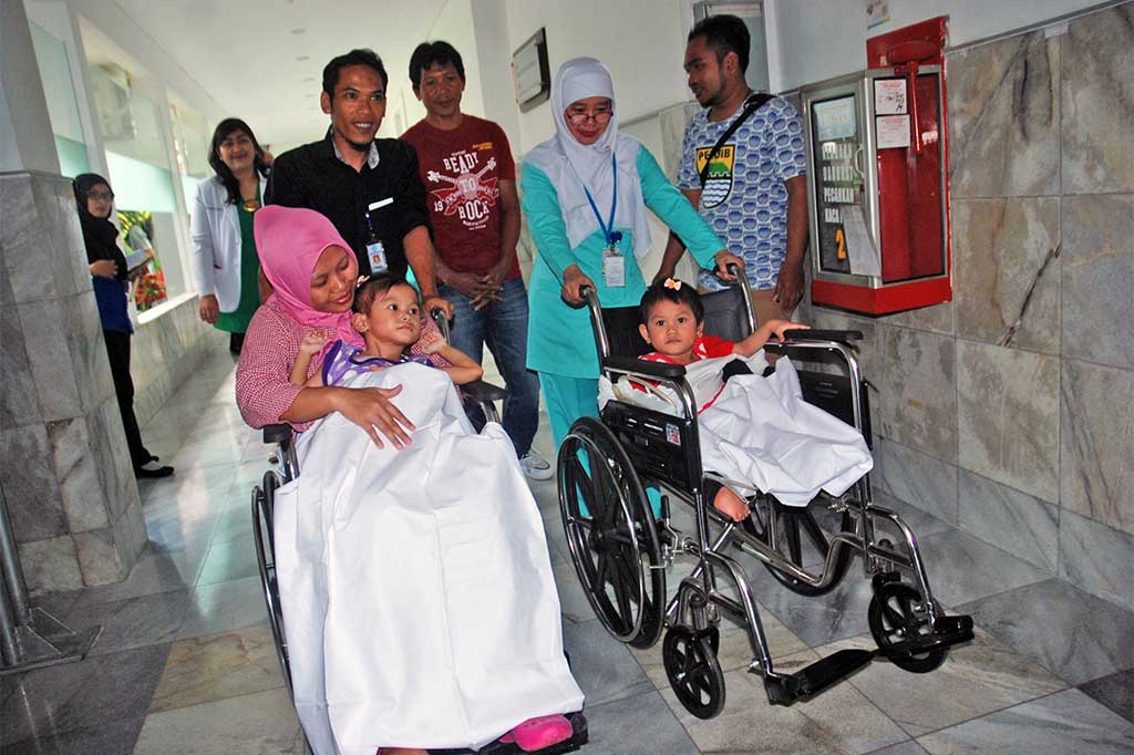 Anak kembar siam jenis Conjoint Twin Ischio Sacrococcygeal (dempet bagian bawah pinggul) Devina (kiri) dan Devani (kanan) bersama orang tua dan perawat saat hendak keluar dari Rumah Sakit Hasan Sadikin (RSHS), Bandung, Jawa Barat, Rabu (19/4/2017). ANTARA/Fahrul Jayadiputra