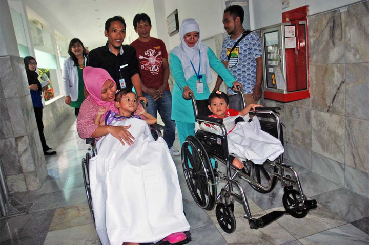 Anak kembar siam jenis Conjoint Twin Ischio Sacrococcygeal (dempet bagian bawah pinggul) Devina (kiri) dan Devani (kanan) bersama orang tua dan perawat saat hendak keluar dari Rumah Sakit Hasan Sadikin (RSHS), Bandung, Jawa Barat, Rabu (19/4/2017). ANTARA/Fahrul Jayadiputra