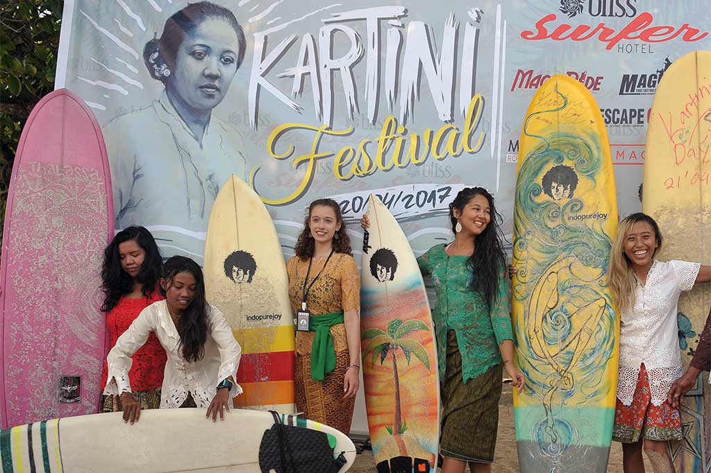 Wisatawan mancanegara bersama para peselancar wanita mengenakan pakaian kebaya saat menyiapkan papan selancarnya untuk menyambut Hari Kartini di Pantai Kuta, Bali, Kamis (20/4/2017). 