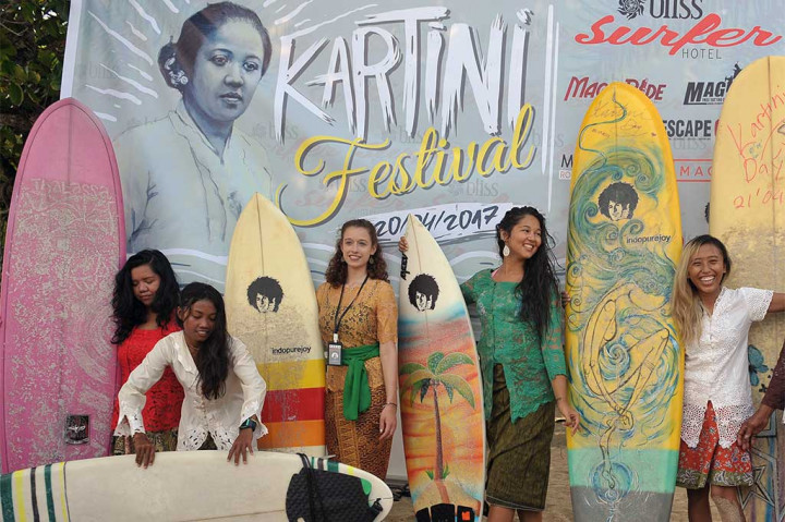Wisatawan mancanegara bersama para peselancar wanita mengenakan pakaian kebaya saat menyiapkan papan selancarnya untuk menyambut Hari Kartini di Pantai Kuta, Bali, Kamis (20/4/2017). 