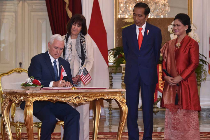 Presiden Jokowi dan Ibu Negara Iriana Joko Widodo menyaksikan Wapres AS Mike Pence dan istrinya Karen Batten menandatangani buku tamu saat kunjungan kehormatan di Istana Merdeka.
