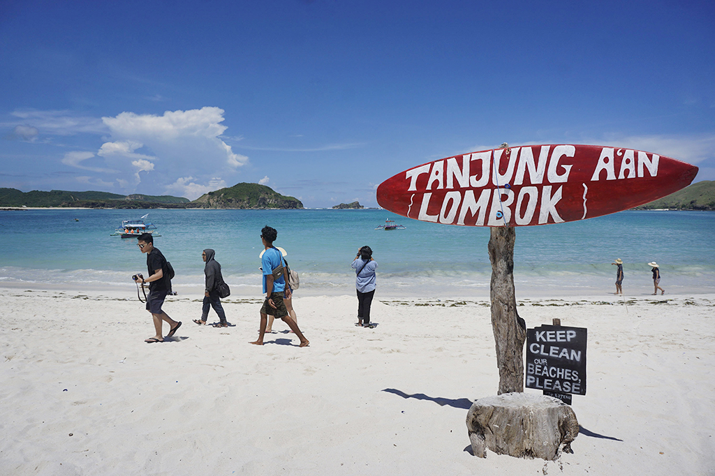 Pengunjung berada di kawasan wisata Pantai Tanjung Aan, Lombok Tengah, Nusa Tenggara Barat, Kamis (20/4/2017). Pantai ini langsung berhadapan dengan Samudera Hindia, dan memiliki garis pantai sepanjang kurang lebih dua kilometer.
