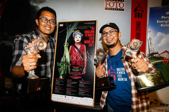 Fotografer Media Indonesia Rommy Pujianto (kiri) dan Unang Ramdhani berpose seusai mendapat penghargaan Anugerah Pewarta Foto Indonesia (APFI) 2017 di Jakarta, Jumat (21/4/2017).