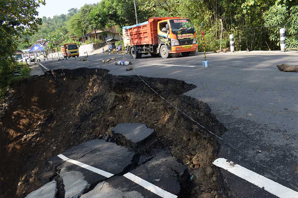 Kendaraan menghindari jalan yang ambles dan longsor di Sawoo, Ponorogo, Jawa Timur, Selasa (25/4/2017).