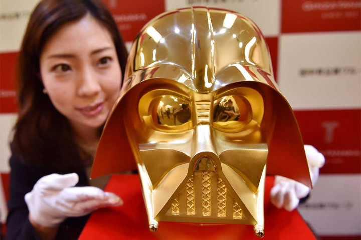 Seorang pegawai toko perhiasan Tanaka Kikinzoku Jewelry memperlihatkan topeng berlapis emas murni Darth Vader, salah satu tokoh jahat di film Star Wars, di toko utama mereka di distrik perbelanjaan Ginza, Tokyo, Kamis (25/4/2017).