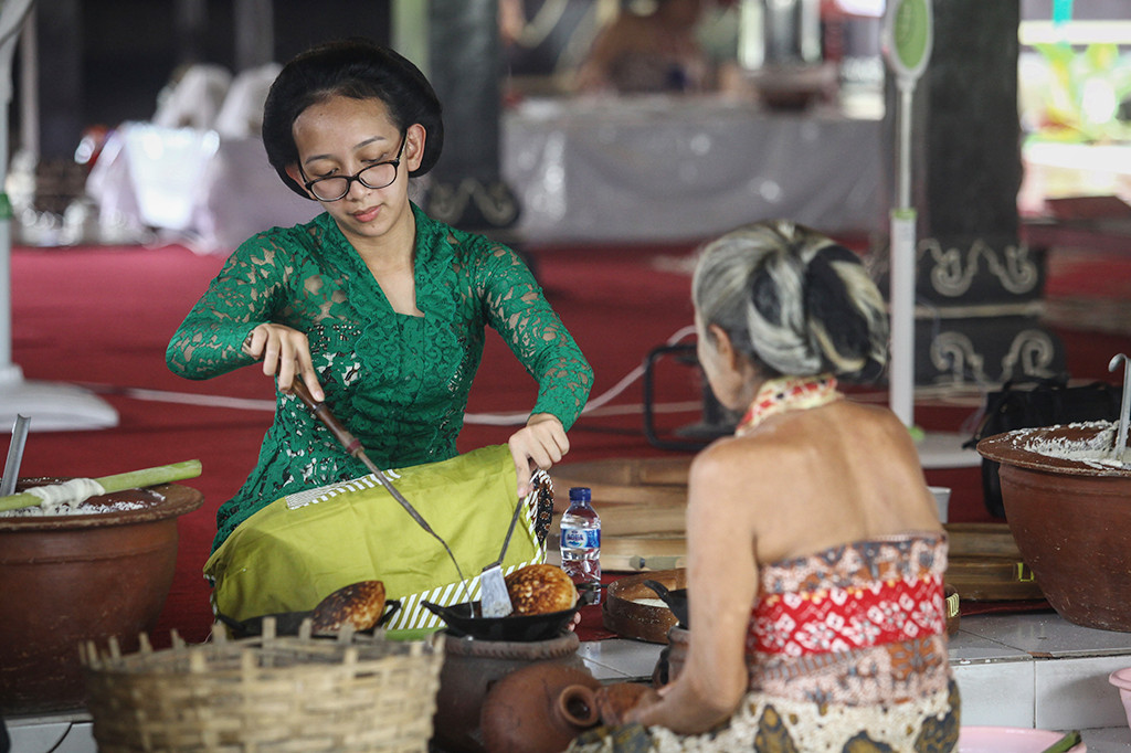Putri Raja Keraton Yogyakarta GKR Bendoro (kiri) membuat kue apem di Bangsal Sekar Kedaton, Keraton Yogyakarta, DI Yogyakarta.