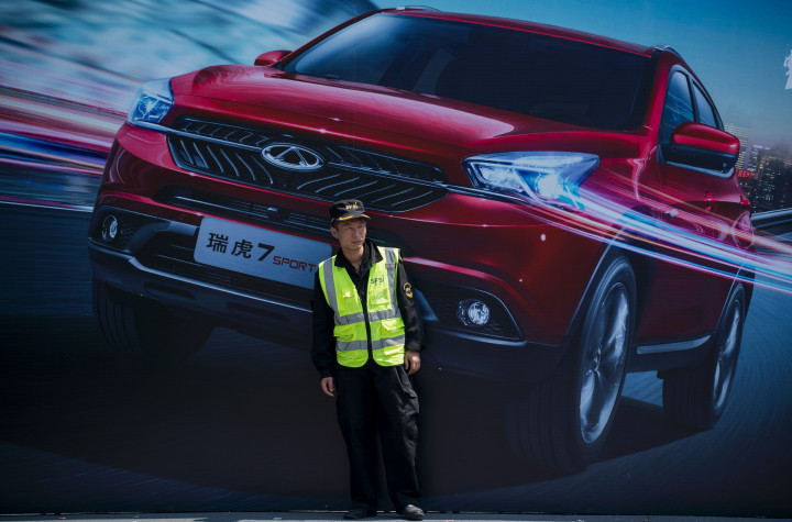 Seorang petugas keamanan berjaga di depan baliho SUV made in China. Penjualan mobil di Tiongkok yang tumbuh pesat mendorong lahirnya banyak merek-merek lokal. 
