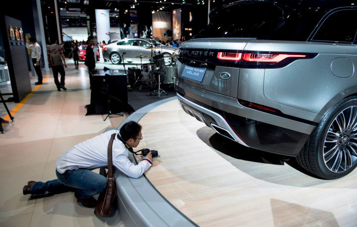 Seorang pengunjung memotret sistem supensi Range Rover Velar. Produk dari Inggris ini mempunyai 'kembaran' bernama Land Wind yang asli Tiongkok. 