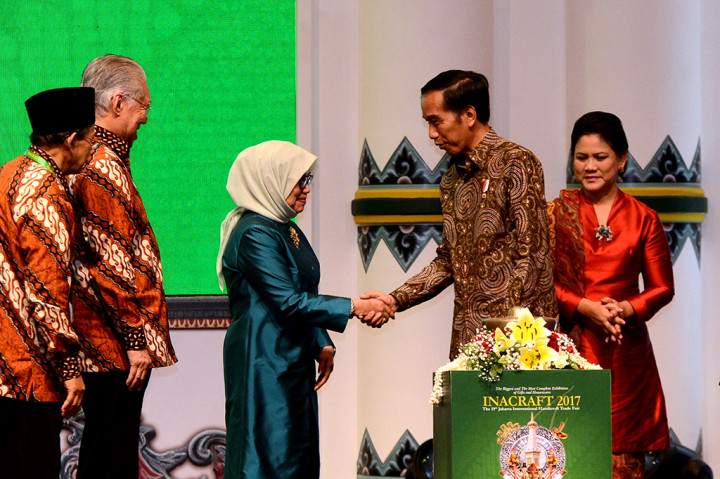Presiden Joko Widodo (kedua kanan) didampingi Ibu Negara Iriana Joko Widodo (kanan) berjabat tangan dengan Ketua Umum Dewan Kerajinan Nasional periode 2014-2019 Mufidah Jusuf Kalla (tengah) disaksikan Menteri Perdagangan Enggartiasto Lukita (kedua kiri) saat pembukaan Inacraft ke-19 di JCC, Jakarta, Rabu (26/4).