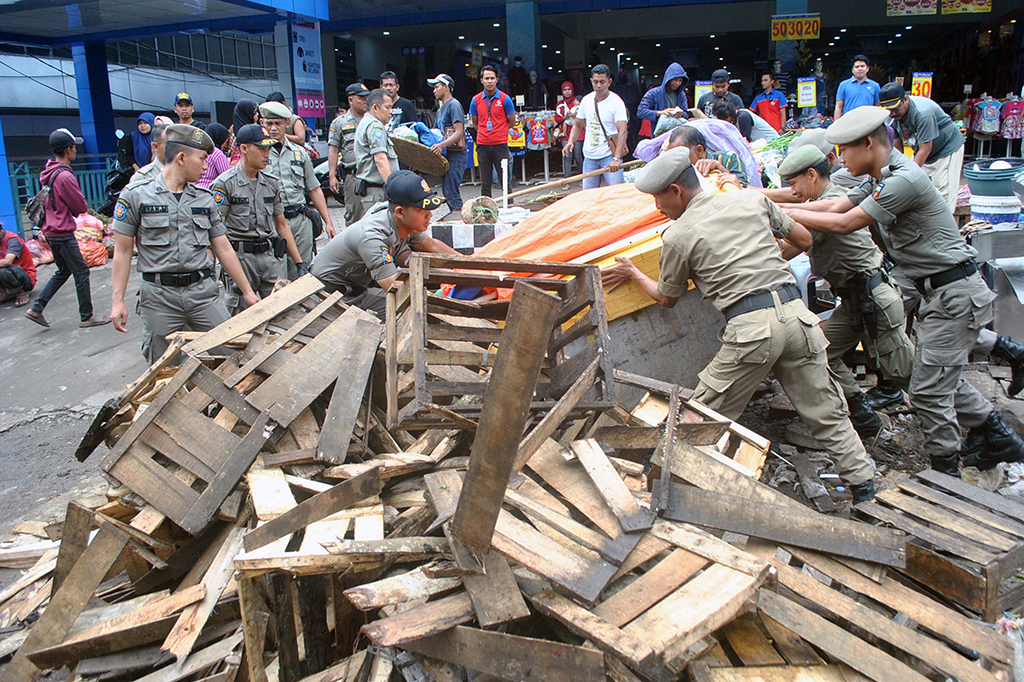 Sejumlah anggota Satpol PP menertibkan lapak dagangan PKL di Jalan Dewi Sartika, Kota Bogor, Jawa Barat.