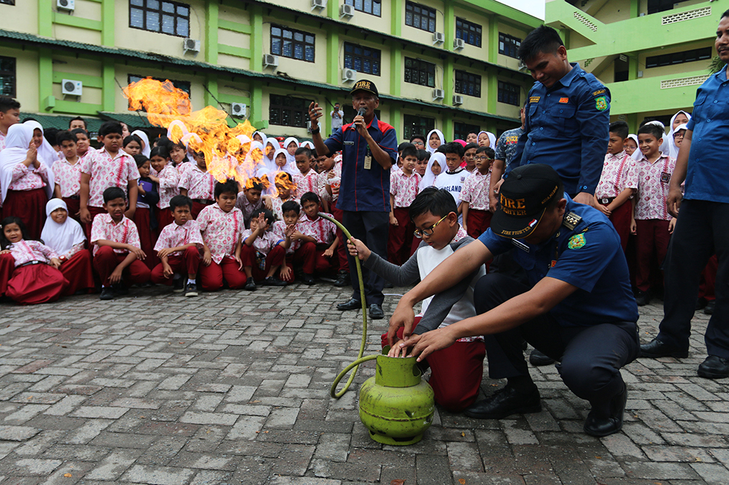 Petugas mengajarkan siswa SD Panca Budi, Medan cara memadamkan api akibat kebocoran tabung gas pada simulasi di Medan, Sumatera Utara, Kamis (27/4/2017).