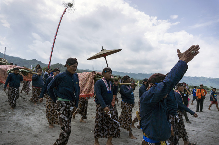 Sejumlah abdi dalem Keraton Yogyakarta membawa sesaji untuk dilarung saat berlangsung prosesi labuhan di Pantai Parangkusumo, Bantul, DI Yogyakarta.