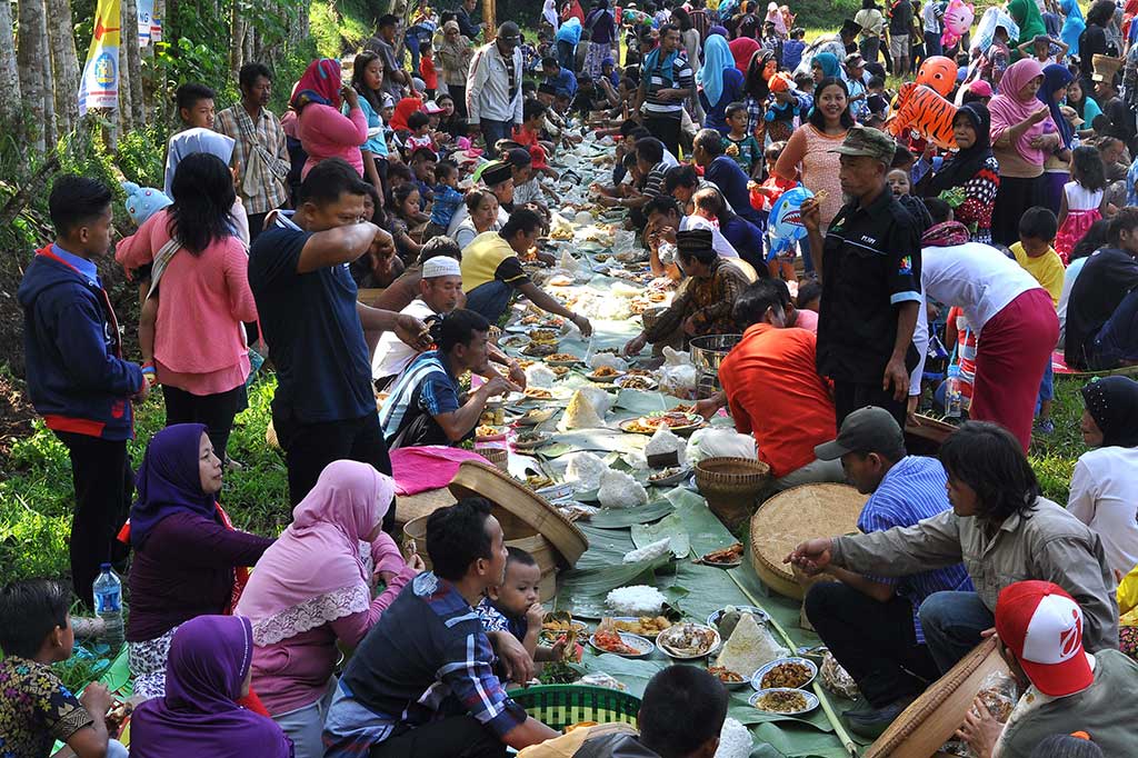 Warga menyantap makanan yang dibawa secara bersama-sama.