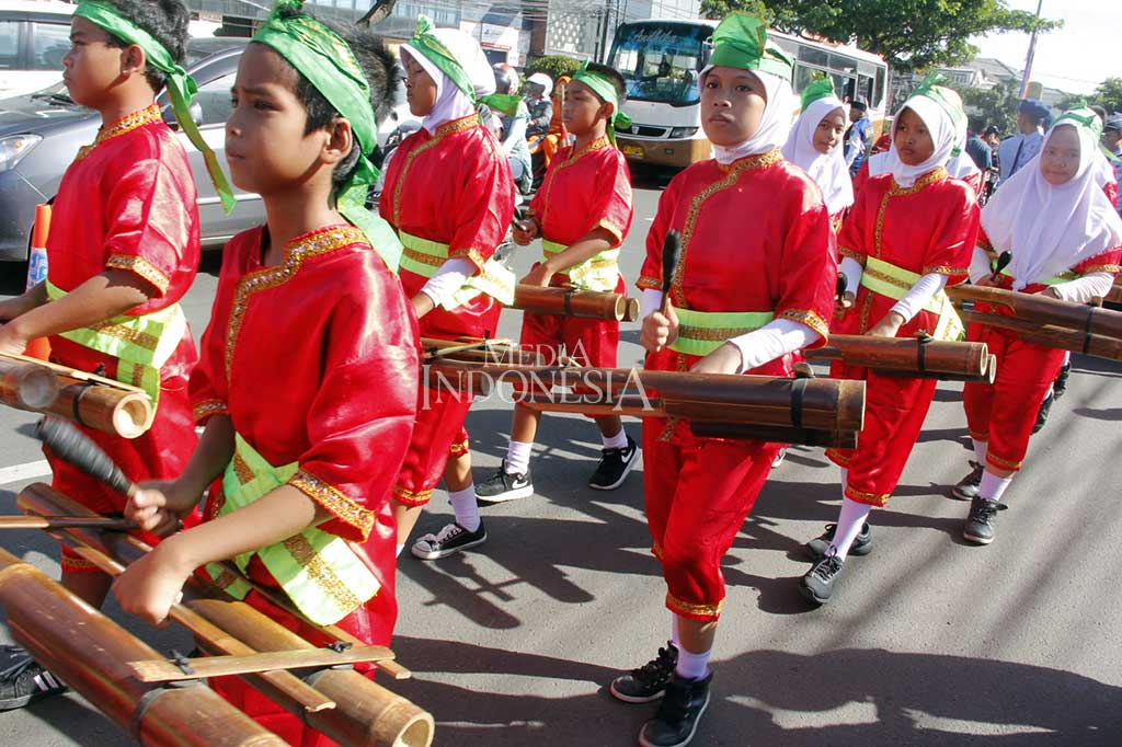 Murid SD memainkan alat tradisional dari bambu saat memeriahkan pawai Parade Budaya Depok.