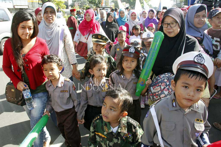 Murid taman kanak-kanak didampingi orang tua mereka turut serta dalam pawai Parade Budaya Depok.