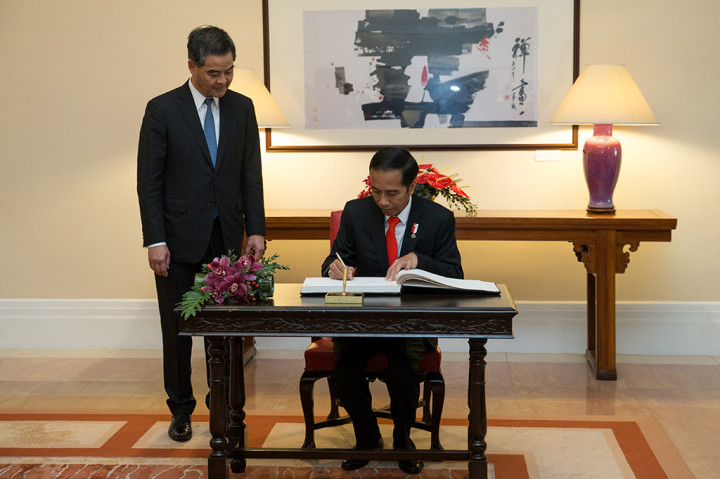 Presiden Jokowi mengisi buku tamu disaksikan Chief Executive Hong Kong Leung Chun-ying.