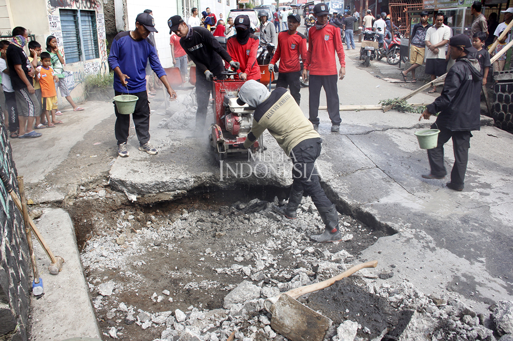 Petugas dari Dinas PU Kota Depok tengah memperbaiki jembatan Kali Krukut sesaat sebelum ambles.