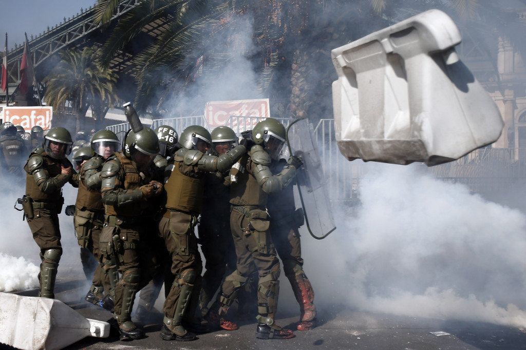 Seorang pengunjuk rasa melemparkan bom molotov ke arah barikade polisi. 