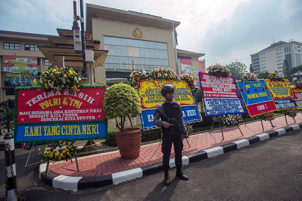 Seorang anggota Polri berjaga di depan Mabes Polri yang dipenuhi puluhan karangan bunga di Jalan Trunojoyo, Jakarta, Rabu (3/5/2017). ANTARA/Widodo S Jusuf