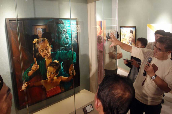 Pelukis Yoannes Pranowo (kanan) menerangkan karya lukisannya berjudul Merawat Bibit, yang merupakan salah satu dari 10 lukisan terbaik pada Pameran Lukisan Para Guru se-Jabodetabek, di Museum Basoeki Abdullah.