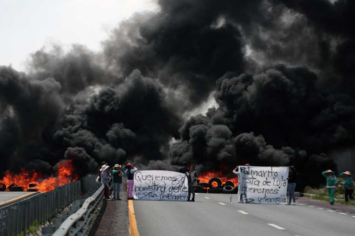 Penduduk desa memblokade jalanan dengan membakar ban untuk memprotes tindakan keras tentara sehari sebelumnya, setelah terjadi bentrokan antara tentara dengan pencuri BBM yang memanfaatkan jaringan pipa minyak raksasa milik negara PEMEX, di Palmarito Tochapan, Puebla, Meksiko, Kamis (4/5/2017).