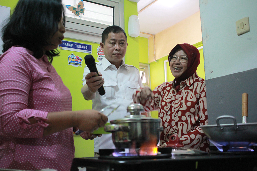 Menteri ESDM Ignasius Jonan (tengah) dan Wali Kota Surabaya Tri Rismaharini (kanan) menyimak penjelasan seorang ibu rumah tangga yang memasak menggunakan gas bumi usai Peresmian Jaringan Gas Bumi Kota Surabaya di Rumah Susun Penjaringan, Surabaya, Jawa Timur.