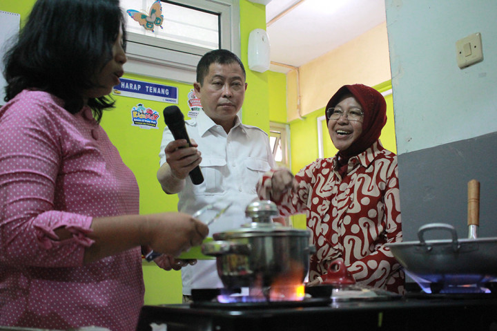 Menteri ESDM Ignasius Jonan (tengah) dan Wali Kota Surabaya Tri Rismaharini (kanan) menyimak penjelasan seorang ibu rumah tangga yang memasak menggunakan gas bumi usai Peresmian Jaringan Gas Bumi Kota Surabaya di Rumah Susun Penjaringan, Surabaya, Jawa Timur.