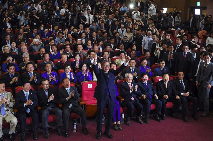 Kandidat Presiden Korea Selatan Moon Jae-in mengangkat tangannya di depan para pendukung, setelah hasil hitung cepat memperlihatkan dia unggul di banding calon lainnya.