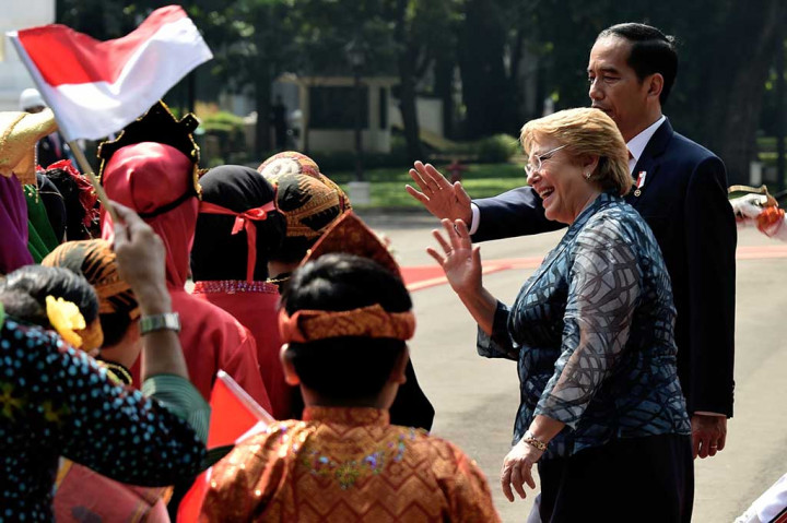 Presiden Chile juga disambut oleh sejumlah anak yang mengenakan pakaian adat Indonesia dan membawa bendera kedua negara.